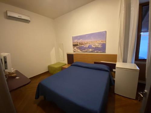 een slaapkamer met een blauw bed en een raam bij B&b Al Porto Novo in Bisceglie