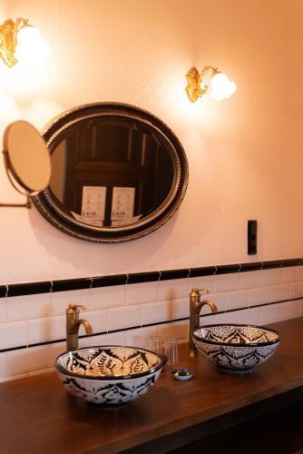 a bathroom with two bowls on a counter with a mirror at Clementine in Kruishoutem