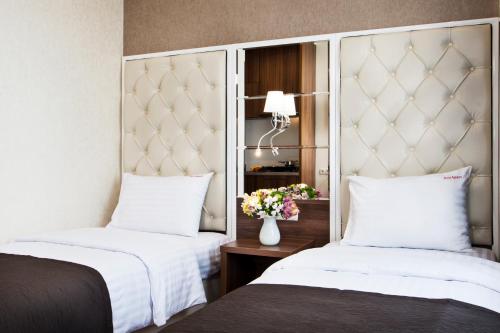 a hotel room with two beds and a mirror at BonApart Hotel by UHM in Kyiv