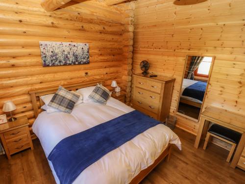 a bedroom with a bed in a log cabin at Pine Lodge in Oakham