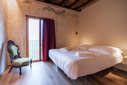 a bedroom with a bed and a chair and a window at Il Molino in Asolo