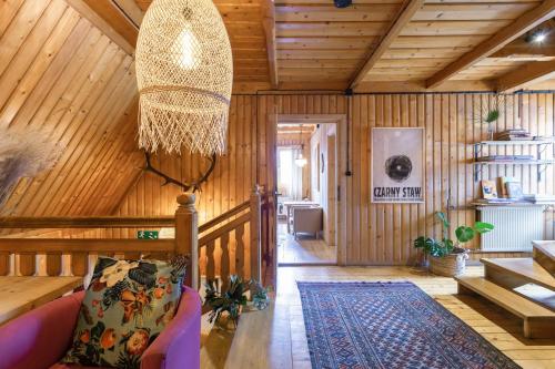 a living room with wooden walls and a ceiling at Leśniczówka u Zięby in Kościelisko