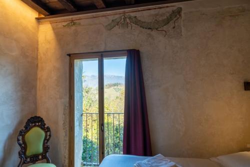 a bedroom with a bed and a window with a view at Il Molino in Asolo
