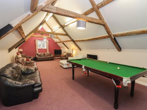 a living room with a pool table in it at Greyhound Barn in Ampney Crucis