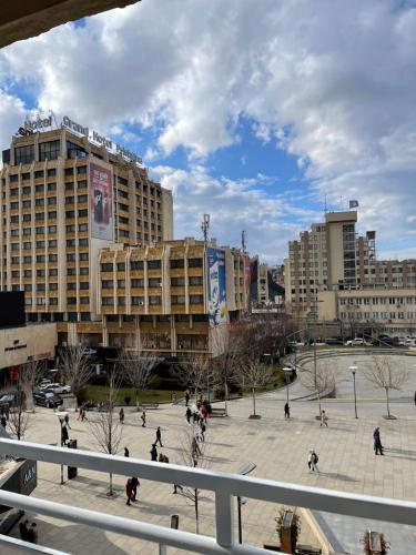 a group of people walking around a plaza in a city at Etern Stays IEG - Zen Apartment in Prishtinë