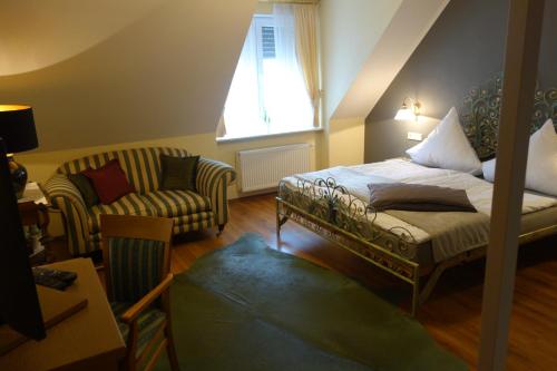 a bedroom with a bed and a chair and a window at Hotel & Restaurant Venner Moor in Senden