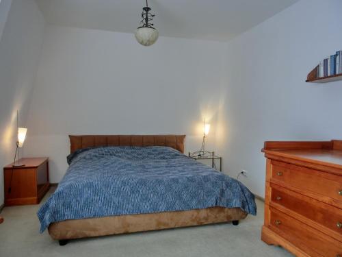 - une chambre avec un lit et une commode en bois dans l'établissement Ferienwohnung A3, à Graal-Müritz