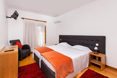 ein Schlafzimmer mit einem großen Bett und einem Stuhl in der Unterkunft Casa Baranda in Ermida