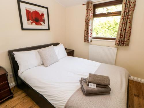 Un dormitorio con una cama blanca y una ventana. en Violet Lodge, en Saltburn-by-the-Sea