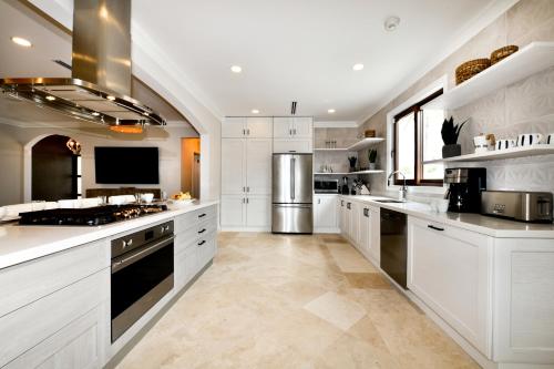 a large kitchen with white cabinets and appliances at Newly Remodeled 5-Bedroom 5-Bath in Tierra del Sol in Malmok