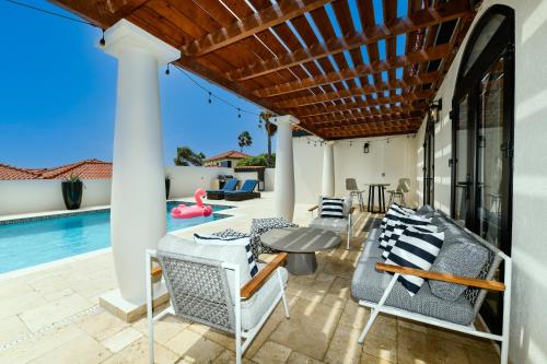 a patio with chairs and a table and a pool at Newly Remodeled 5-Bedroom 5-Bath in Tierra del Sol in Malmok