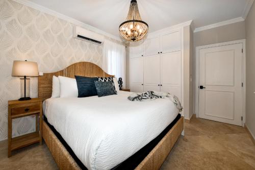 a bedroom with a large white bed and a chandelier at Newly Remodeled 5-Bedroom 5-Bath in Tierra del Sol in Malmok