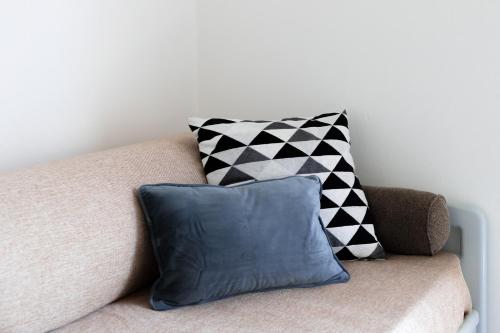 a couch with a black and white pillow on it at Case Costa Degli Dei in Santa Domenica
