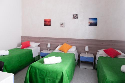 a room with three beds with green and orange sheets at Case Costa Degli Dei in Santa Domenica