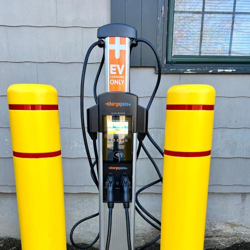a parking meter sitting next to two yellow poles at The Carriage House Inn Newport in Middletown