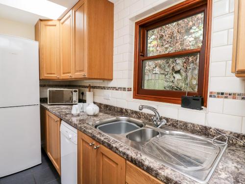 a kitchen with a sink and a white refrigerator at Penlon in Aberystwyth