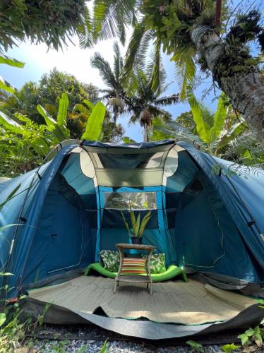 a blue tent with a chair in front of it at Hostel Trópico de Capricórnio - Tenório in Ubatuba