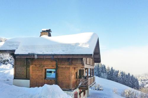 une cabane en rondins avec de la neige au-dessus dans l'établissement chalet Amitie familial de luxe avec JACUZZI, HEBERGEMENT MULTIPASS ETE, WIFI fibre, 150 m des pistes de ski et randonnées, aux Gets