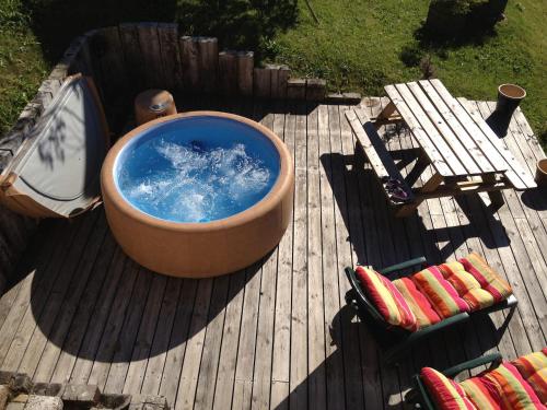 a large tub sitting on top of a wooden deck at Luxury Family Ski Chalet - Jacuzzi BBQ - Near Lake Golf - Multipass access 60 Summer activities - Sleep 10 in Les Gets