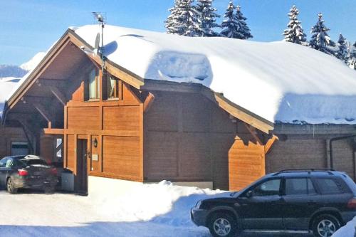 une maison recouverte de neige avec une voiture garée devant dans l'établissement chalet Amitie familial de luxe avec JACUZZI, HEBERGEMENT MULTIPASS ETE, WIFI fibre, 150 m des pistes de ski et randonnées, aux Gets