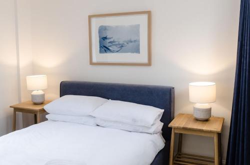 a bedroom with a bed with two side tables with lamps at Cozy Broadstairs Hideaway - 1 min walk to beach in Kent