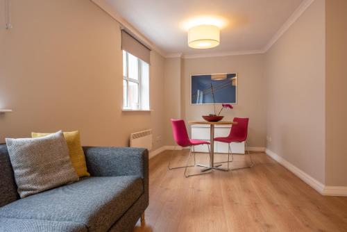 a living room with a couch and a table at PREMIER SUITES Reading in Reading