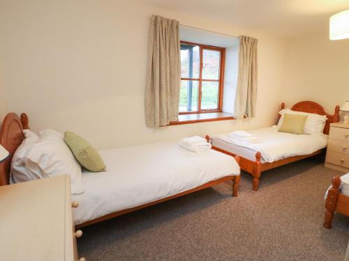 a bedroom with two beds and a window at Stewart in Pitlochry