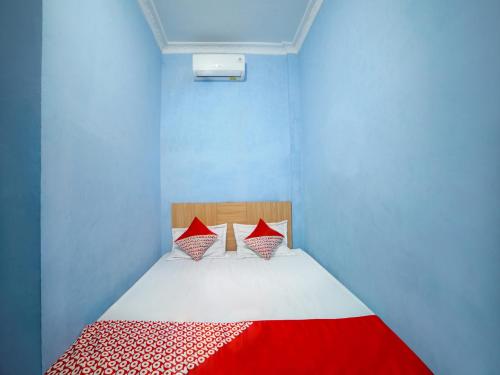 Un pat sau paturi într-o cameră la OYO 90922 Gurusinga Guesthouse