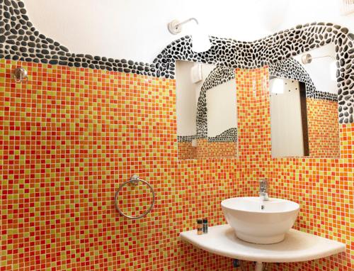 a bathroom with a sink and a mirror at Suites of the Gods Cave Spa Hotel in Megalochori
