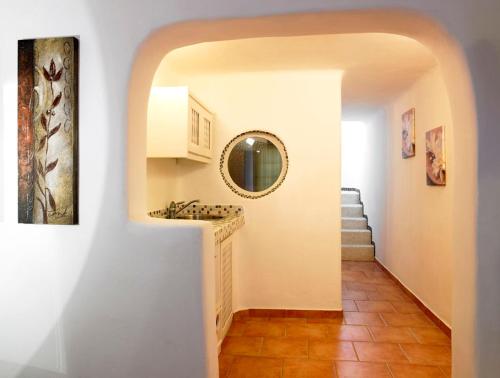 a hallway with a sink and a mirror at Suites of the Gods Cave Spa Hotel in Megalochori