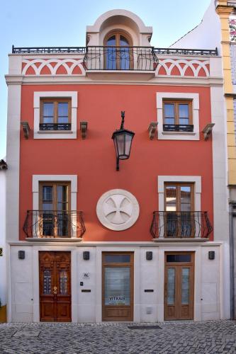 a red building with a large symbol on it at Family House Cup in Tomar