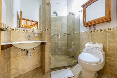 y baño con aseo, lavabo y ducha. en Ayenda Llanogrande Inn, en Rionegro