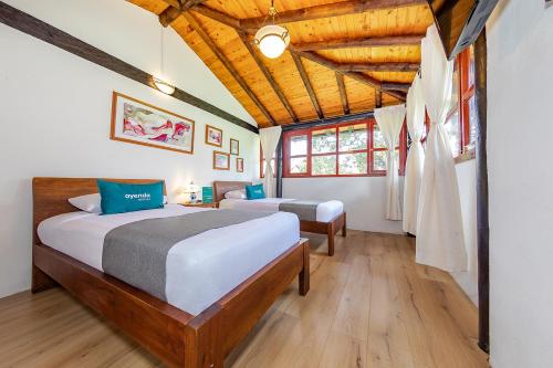 1 Schlafzimmer mit 2 Betten und Holzdecke in der Unterkunft Ayenda Llanogrande Inn in Rionegro