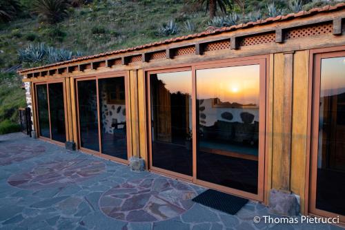 a wooden house with glass doors on a patio at Casa Rural La Palizada in Benchijigua