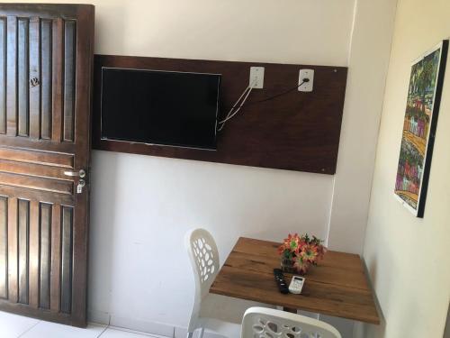 uma sala de jantar com uma mesa e uma televisão na parede em Olinda mar pousada em Olinda