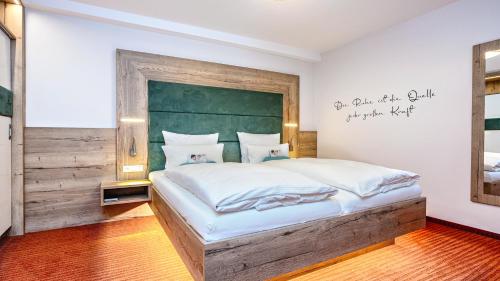 a bedroom with a large bed with a green headboard at Kur- und Wellnesshotel Förch in Bad Wörishofen