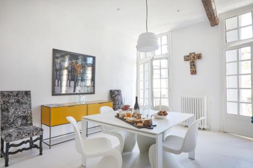 een witte eetkamer met een witte tafel en stoelen bij Beautiful Art Lovers Apartment in Béziers