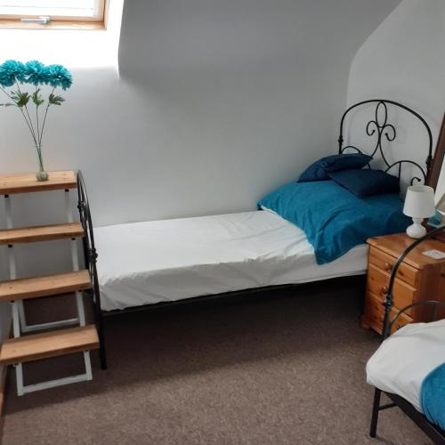 1 dormitorio con 2 camas individuales y estante en Honeysuckle Cottage en Wiggenhall Saint Germans