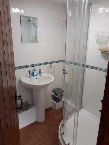 a bathroom with a sink and a shower at Honeysuckle Cottage in Wiggenhall Saint Germans