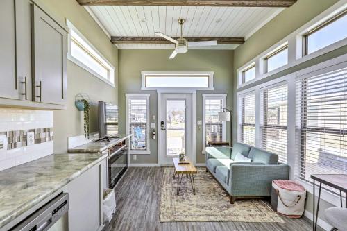 a kitchen and living room with a couch and windows at Chic Tiny Home with Pool Access about 8 Mi to Dtwn! in Austin