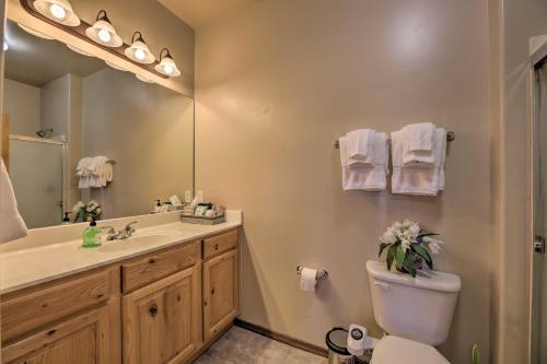 a bathroom with a sink and a toilet and a mirror at Near Lake and Trails Show Low Condo with Grill! in Show Low
