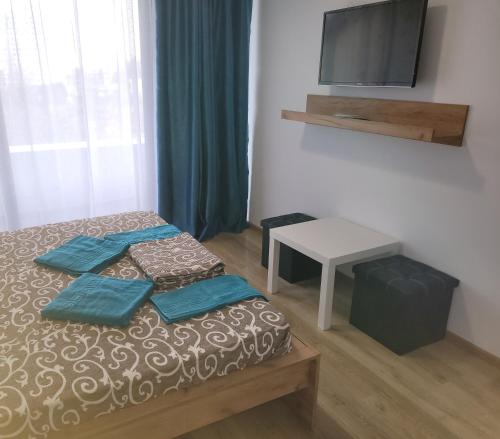 Schlafzimmer mit einem Bett, einem TV und einem Tisch in der Unterkunft Vila Ayra in Eforie Nord