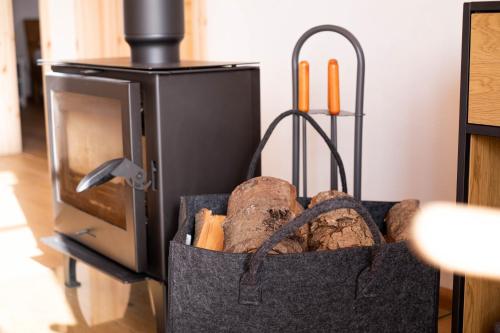 a bag full of logs in front of a stove at Hof Ruemland Ferienwohnungen in Hollingstedt