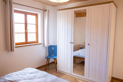 a bedroom with a closet with a mirror at Hof Ruemland Ferienwohnungen in Hollingstedt