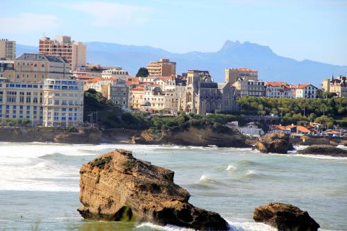 a view of a city with a rock in the water at Hotel De L'Océan in Biarritz