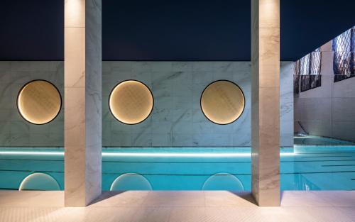 a swimming pool with three circular lights on the wall at Hotel Lutetia in Paris