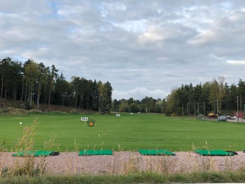 a large green field with trees in the background at Hotel Stallbacken Nagu in Nauvo