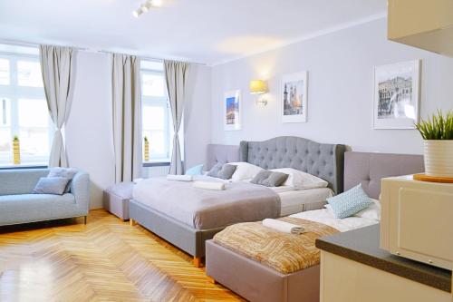 uma sala de estar com duas camas e um sofá em 21 Floriańska Street Apartments na Cracóvia