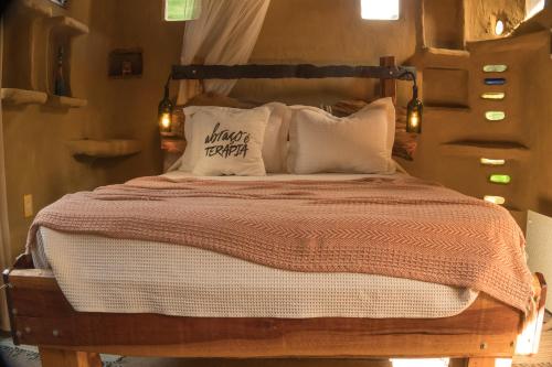 a bedroom with a bed with a wooden headboard and pillows at Lo De Ro in Barra de Valizas