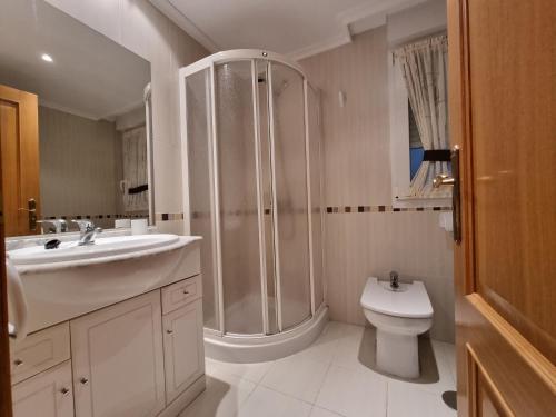 a bathroom with a shower and a sink and a toilet at Apartamentos Rapadoira in Foz